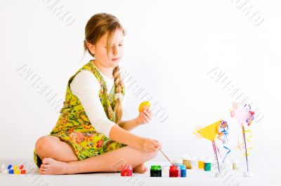 Young girl painting eggs