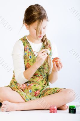 Young girl concentrated on painting eggs for easter