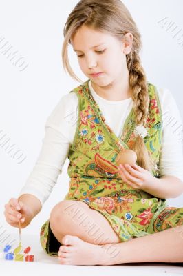 Young girl painting eggs for Easter