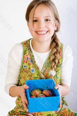Young girl presenting a box with painted eggs