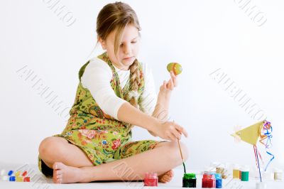 Young girl playing with paint and eggs