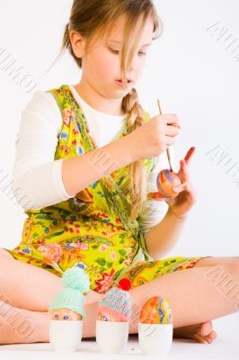 Young girl painting easter eggs