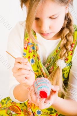 Young girl painting eggs for easter