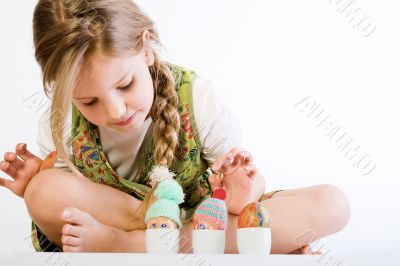 Young girl checking her painted eggs