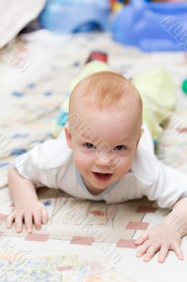 Playful child crawling on the carpet in living room