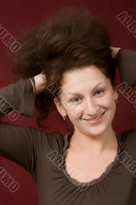 Portrait of the young smiling woman on a dark background.