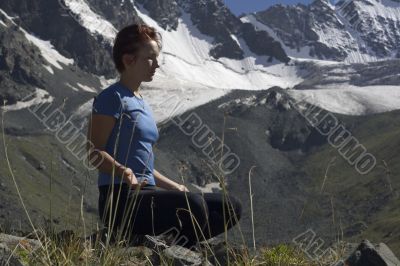 Meditating girl in the mountains