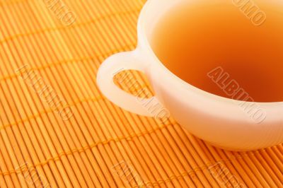 Cup of tea on orange rattan mat
