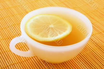 Cup of tea with lemon in warm golden light Cup of tea with lemon in warm golden light
