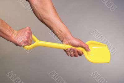 Strong hands and children`s shovel