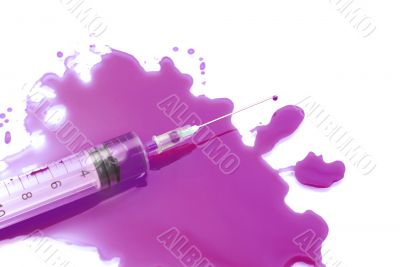 Syringe in a pool of a violet liquid