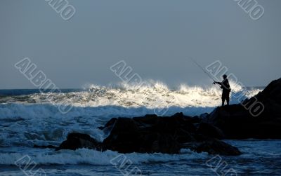 fisherman silhouette on rocks
