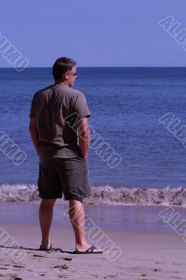 older man looking out upon ocean