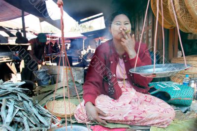 asian market seller smoking a sigar