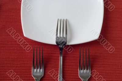 three forks and porcelain plate
