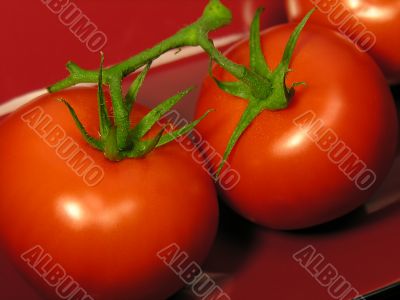 The perfect red tomatoes on on a red dish
