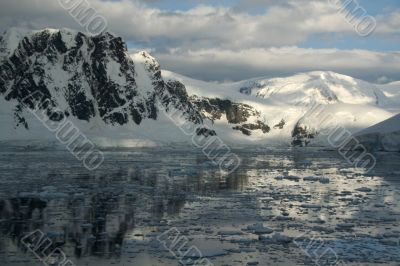 Twilight: Icy mountains reflected on calm seas