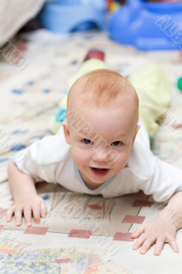 Playful child crawling on the carpet in living room