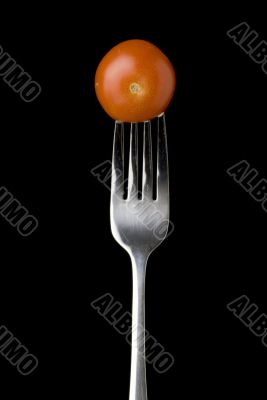 Fresh cherry tomato on a silver for against a black background