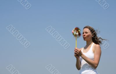 Young woman blowing a colorful pinwheel