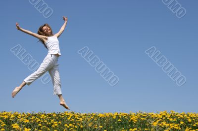 Pretty girl dancing in flowering meadow