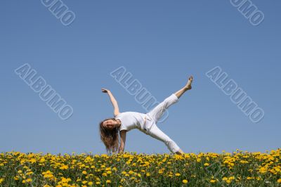 Smiling young woman exercising in dandelion field
