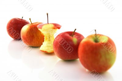 Apple core among whole apples, focus on the core