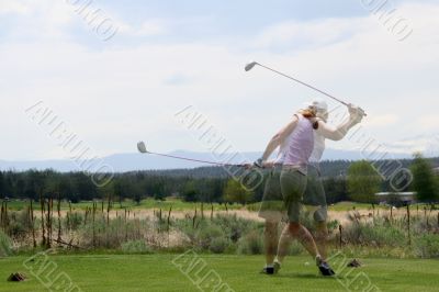 Action blur: Lady golfer hitting ball from tee