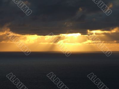 Rays of sun passing trough clouds at sea side