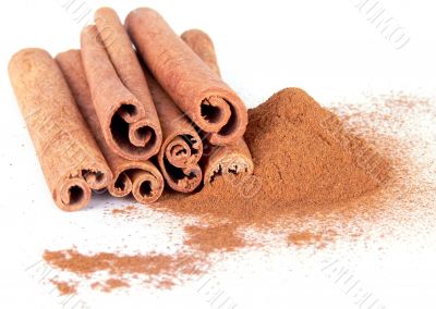 Cinnamon powder and sticks on white