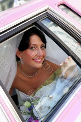 Smiling bride in wedding car limousine