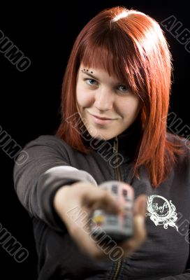 Girl watching television and using the remote control