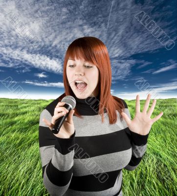 Redhead girl singing karaoke on microphone