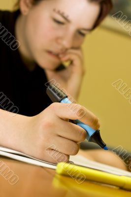 Student girl biting nails while studying