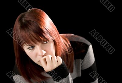 Pensive redhead girl biting nail