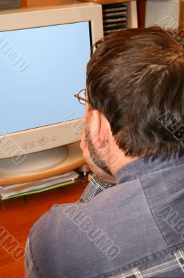 The man sitting at a table on a workplace. The man sitting at a table on a workplace.