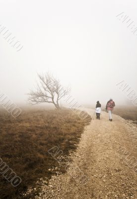 Couple hiking uphill on a bad weather day