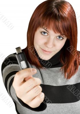 Redhead girl holding a flash drive at camera