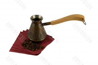 Ibrik with coffee on a serviette with coffee beans