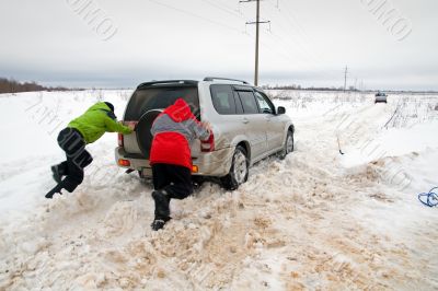 Two men pushing a car