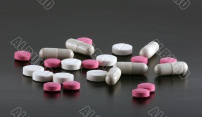 Tablets and pills on a black background