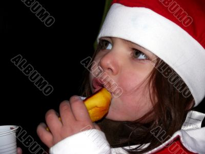 Cristmas girl eating bun