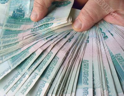 Hands holding many of the Russian banknotes