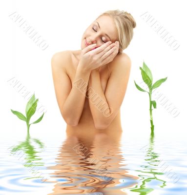 blonde with flower petals and green plants in spa