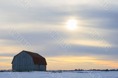 Old wooden barn in a snowy field