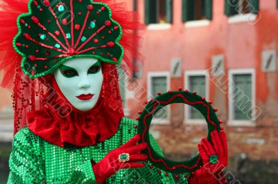 The Venetian mask in a bright green suit.