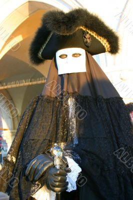 The Venetian mask in a black suit.