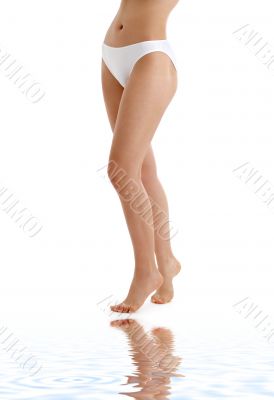 long legs in bikini panties on white sand