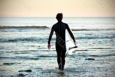 picture of a young surfer walking on the water