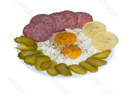Fried eggs with salami, lemon and pickles